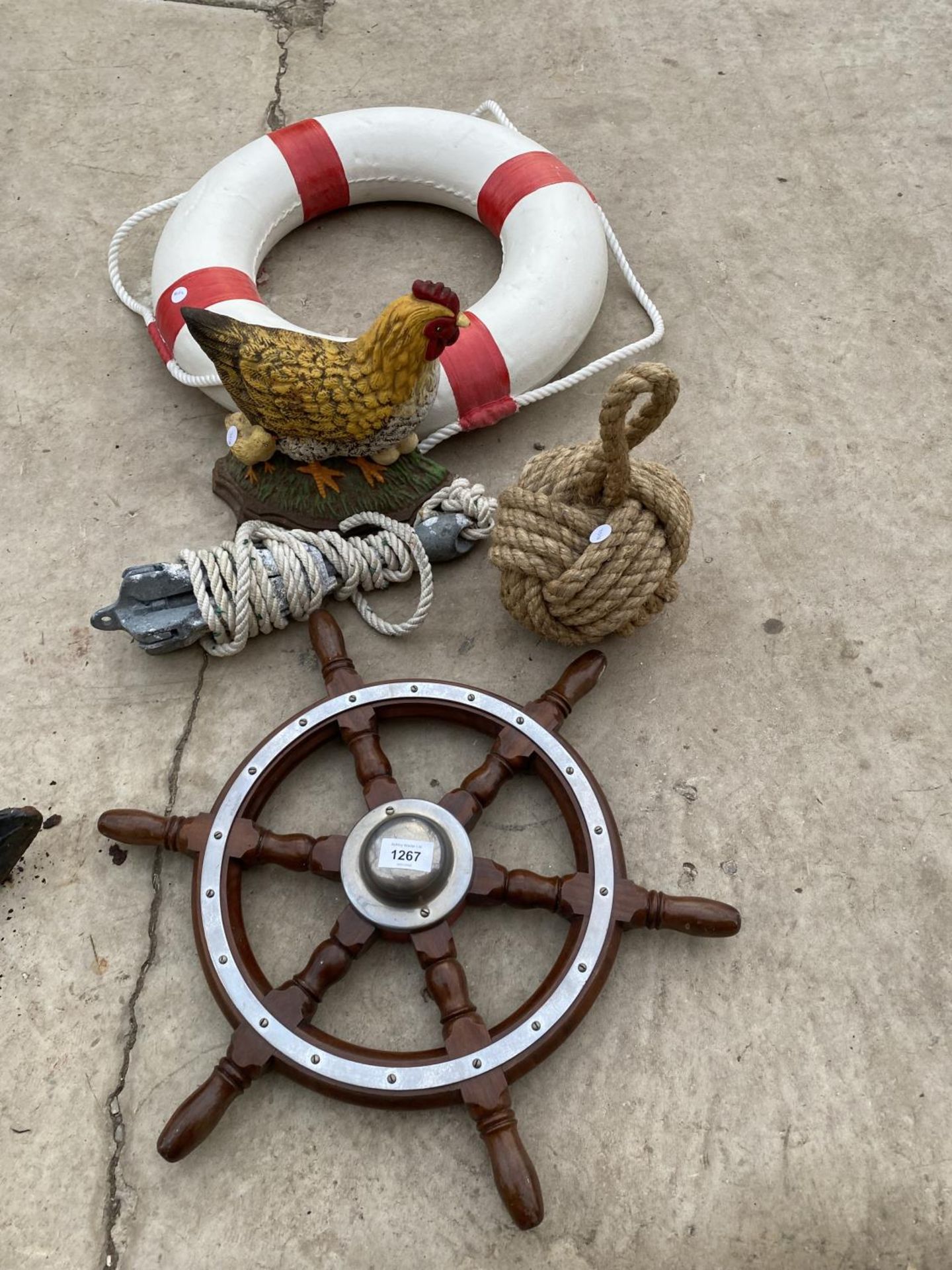 AN ASSORTMENT OF ITEMS TO INCLUDE A SHIPS WHEEL, A BOYANCE AID AND A FOLDING ANCHOR ETC