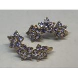 A PAIR OF 9 CARAT GOLD EARRINGS WITH EIGHTEEN PALE BLUE STONES TO FORM THREE IN LINE FLOWERS ON EACH