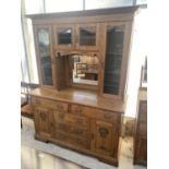 AN OAK ART NOUVEAU SIDEBOARD WITH MIRRORED UPPER PORTION WITH GLAZED BEVEL EDGED DOORS, ON BASE,