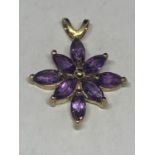 A 9 CARAT GOLD MARKED 375 PENDANT WITH EIGHT PURPLE STONES IN A FLOWER DESIGN GROSS WEIGHT 1.9 GRAMS