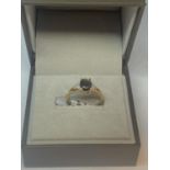 A 9 CARAT GOLD RING MARKED 375 WITH A CENTRAL SMOKEY QUARTZ STYLE STONE AND THREE CLEAR STONES ON