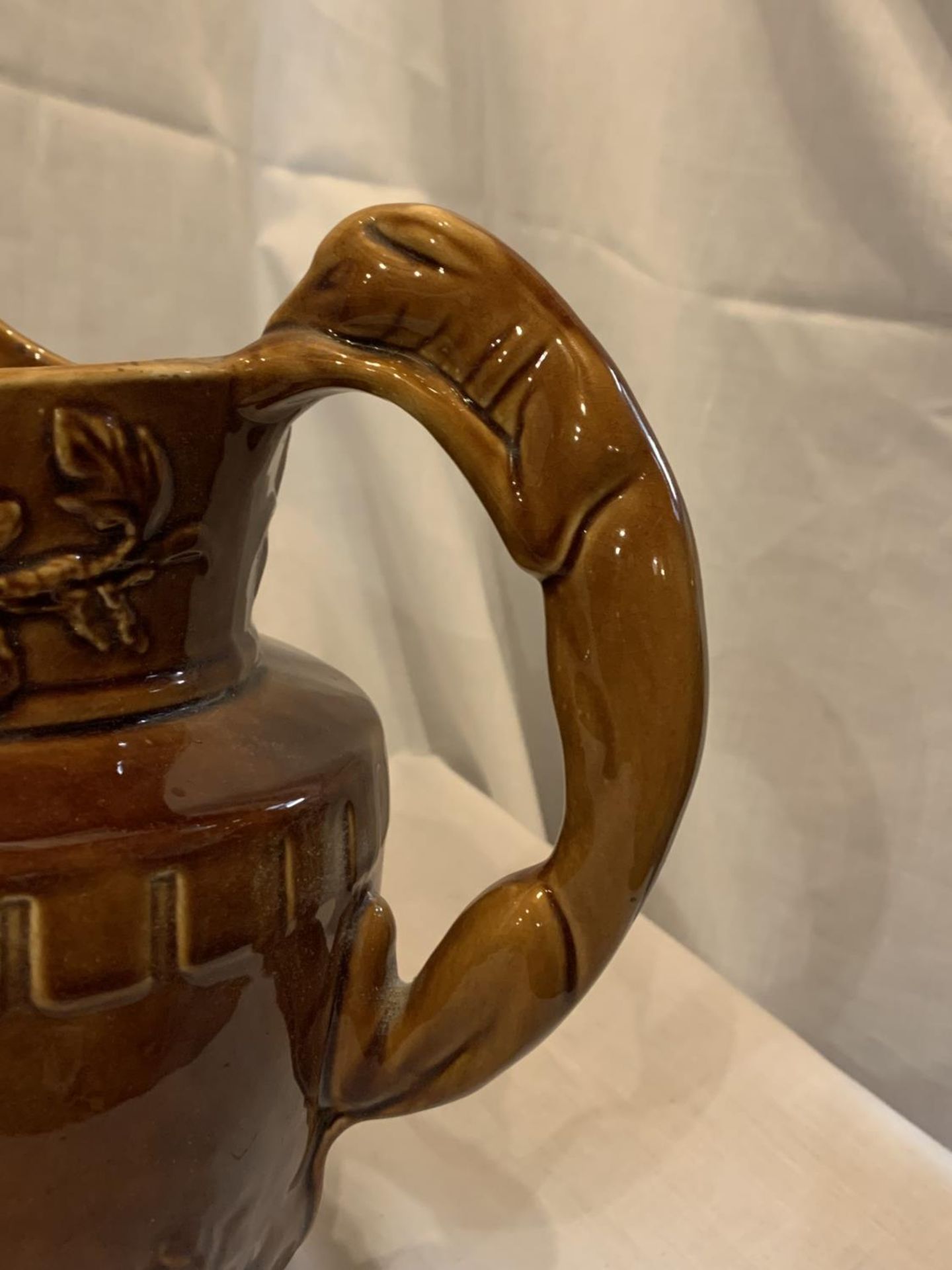 A WOOD LARGE TREACLE GLAZE JUG WITH BEAR AND HUNTING DECORATION AND A HOUND HANDLE - Image 4 of 5