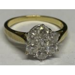 AN 18 CARAT YELLOW GOLD RING WITH 1 CARAT OF DIAMONDS IN A SEVEN STONE FLOWER DESIGN SIZE O/P IN A