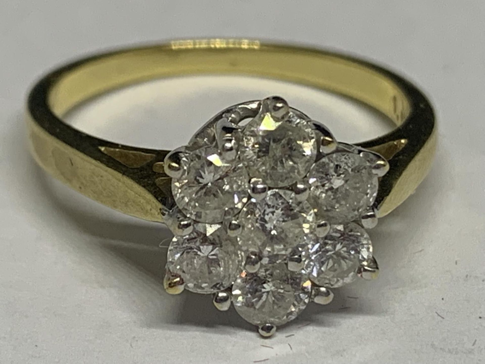 AN 18 CARAT YELLOW GOLD RING WITH 1 CARAT OF DIAMONDS IN A SEVEN STONE FLOWER DESIGN SIZE O/P IN A