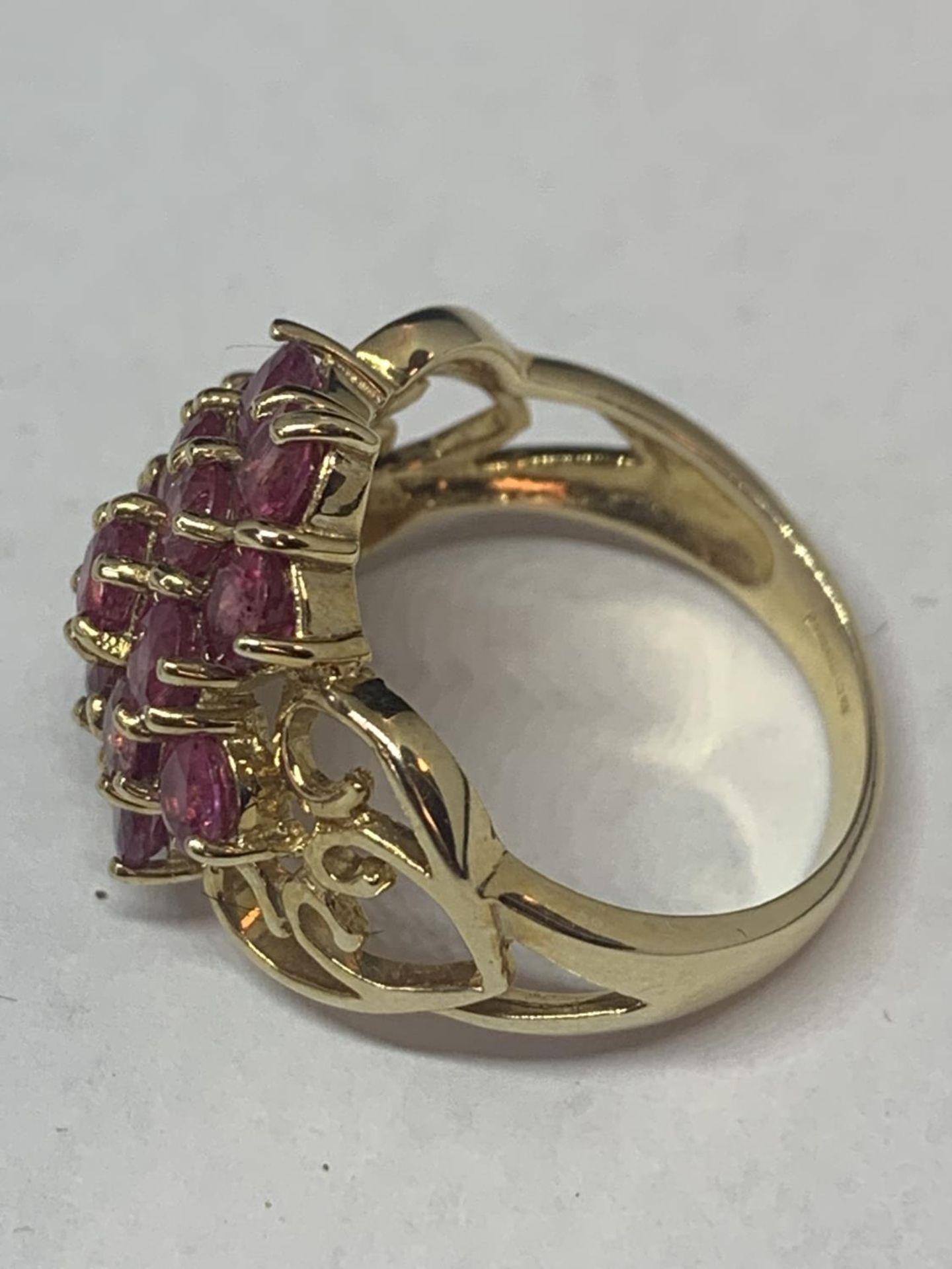 A 9 CARAT GOLD RING MARKED 375 WITH FIFTEEN PINK COLOURED STONES IN A CLUSTER DESIGN AND - Image 2 of 8