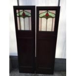 A PAIR OF EARLY 20TH CENTURY NARROW COLOURED GLAZED AND LEADED DOORS, 18" WIDE EACH APPROX
