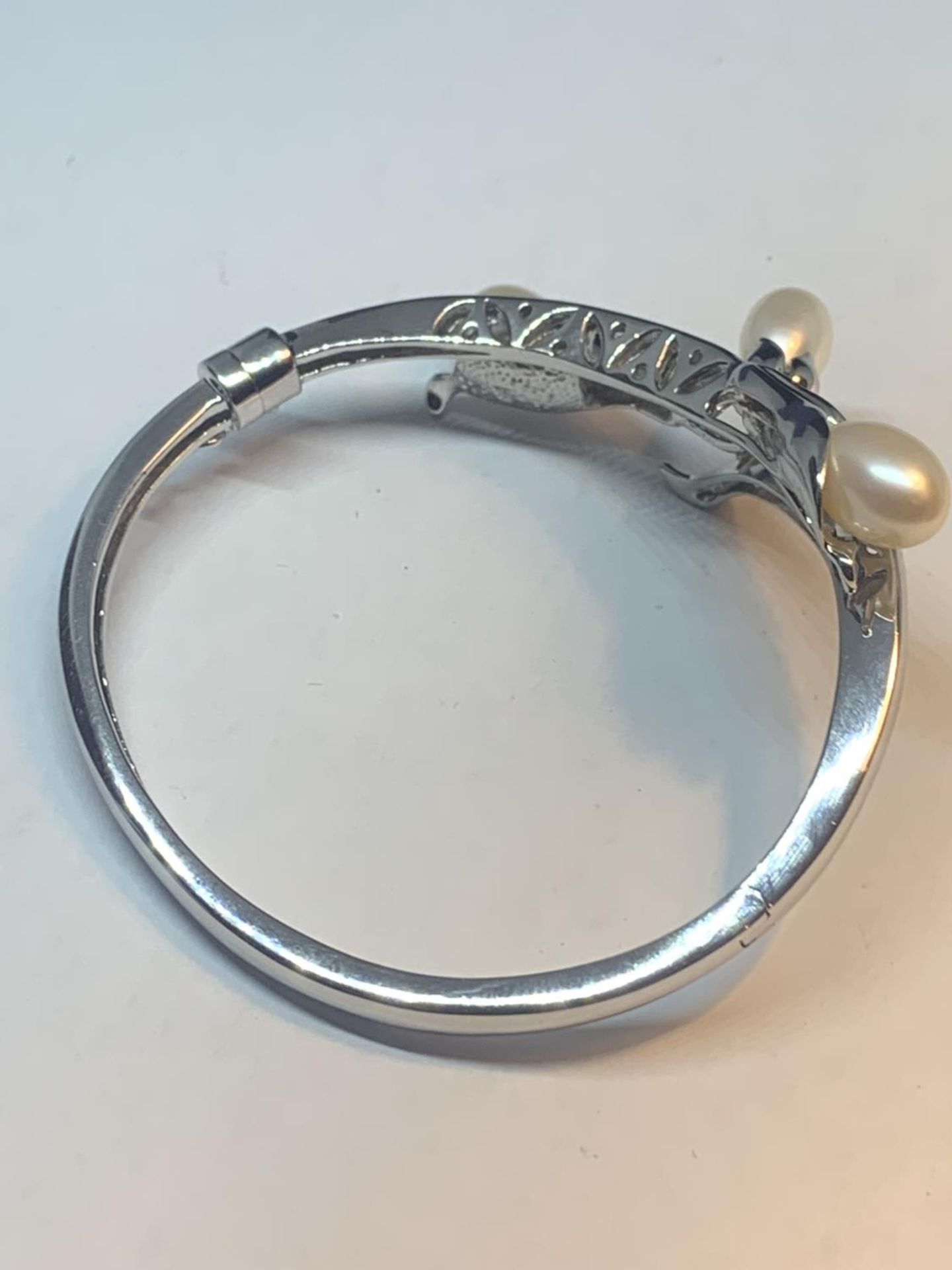 A MARKED 925 SILVER BANGLE WITH THREE PEARLS IN A LILY DESIGN GROSS WEIGHT 23.9 GRAMS WITH A - Image 3 of 5