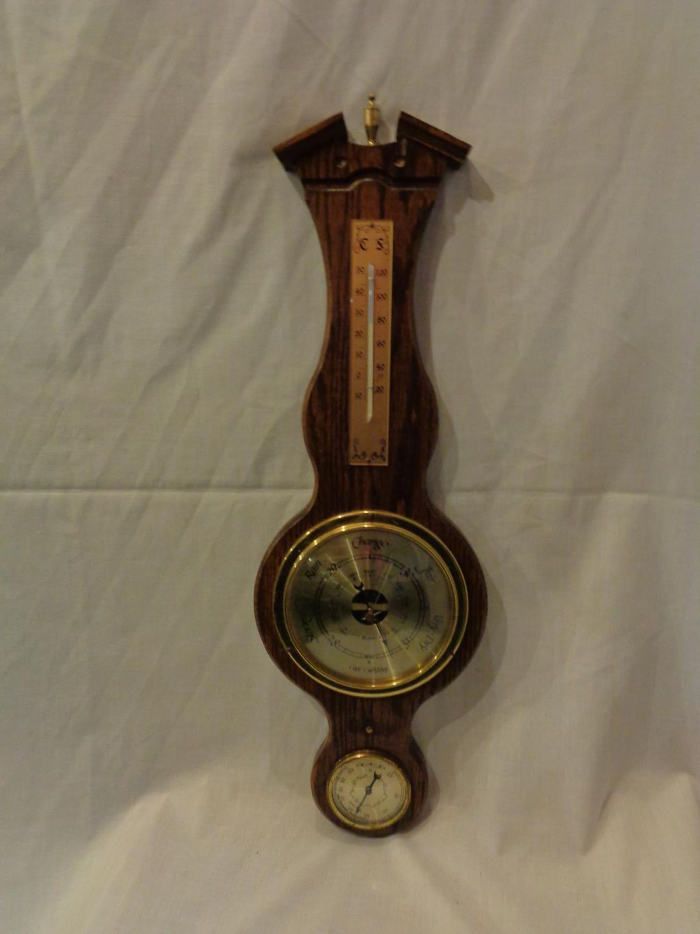 A WOODEN BAROMETER AND THERMOMETER