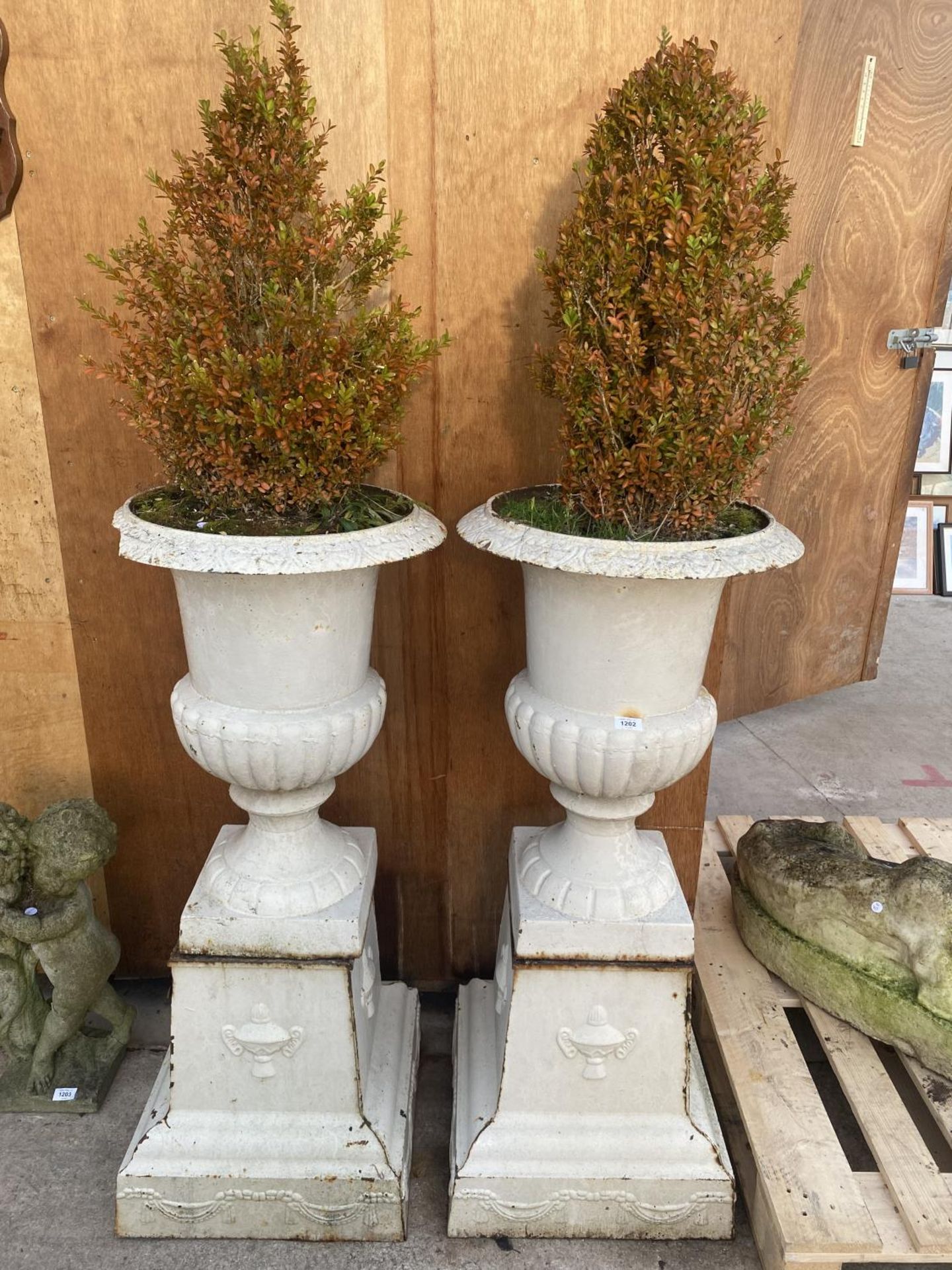 A PAIR OF LARGE CAST IRON URN PLANTERS ON PEDASTEL BASES (ONE A/F) (H:115CM)