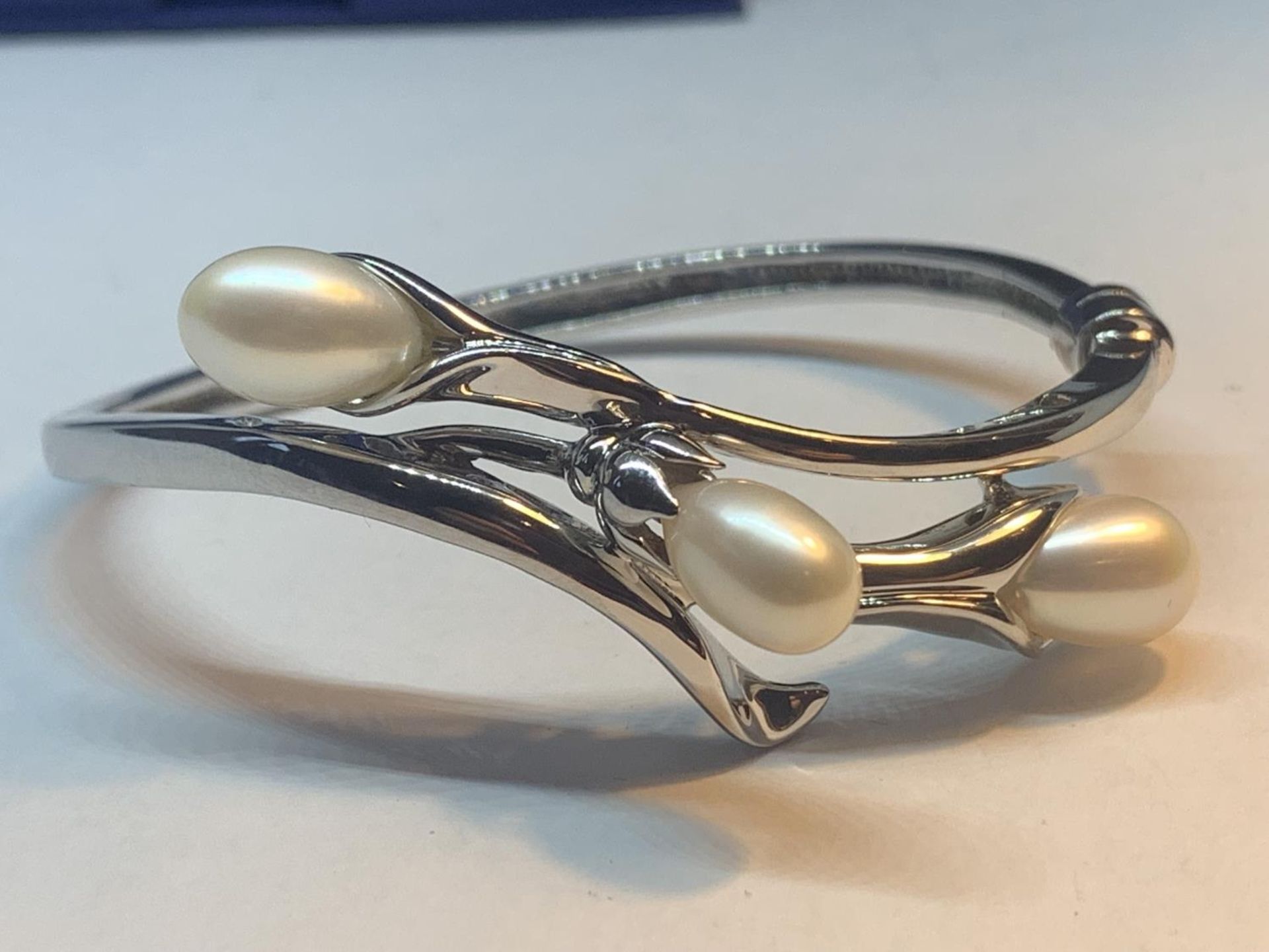 A MARKED 925 SILVER BANGLE WITH THREE PEARLS IN A LILY DESIGN GROSS WEIGHT 23.9 GRAMS WITH A - Image 4 of 5