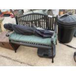 A SLATTED METAL GARDEN BENCH AND A PARASOL