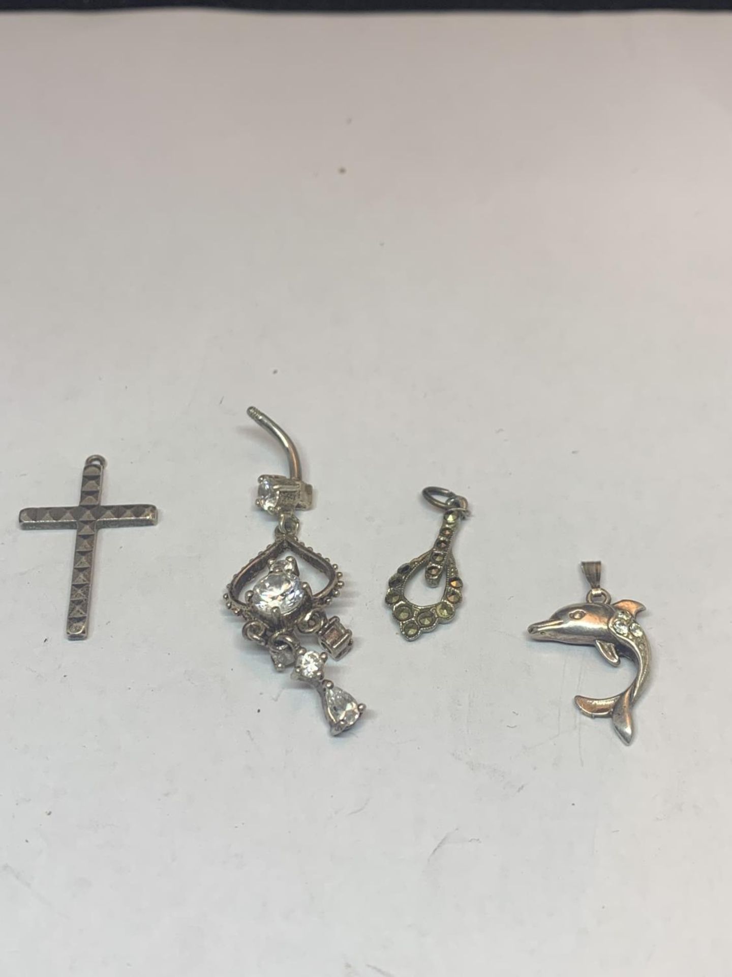 FOUR MARKED SILVER PENDANTS TO INCLUDE A CROSS AND A DOLPHIN