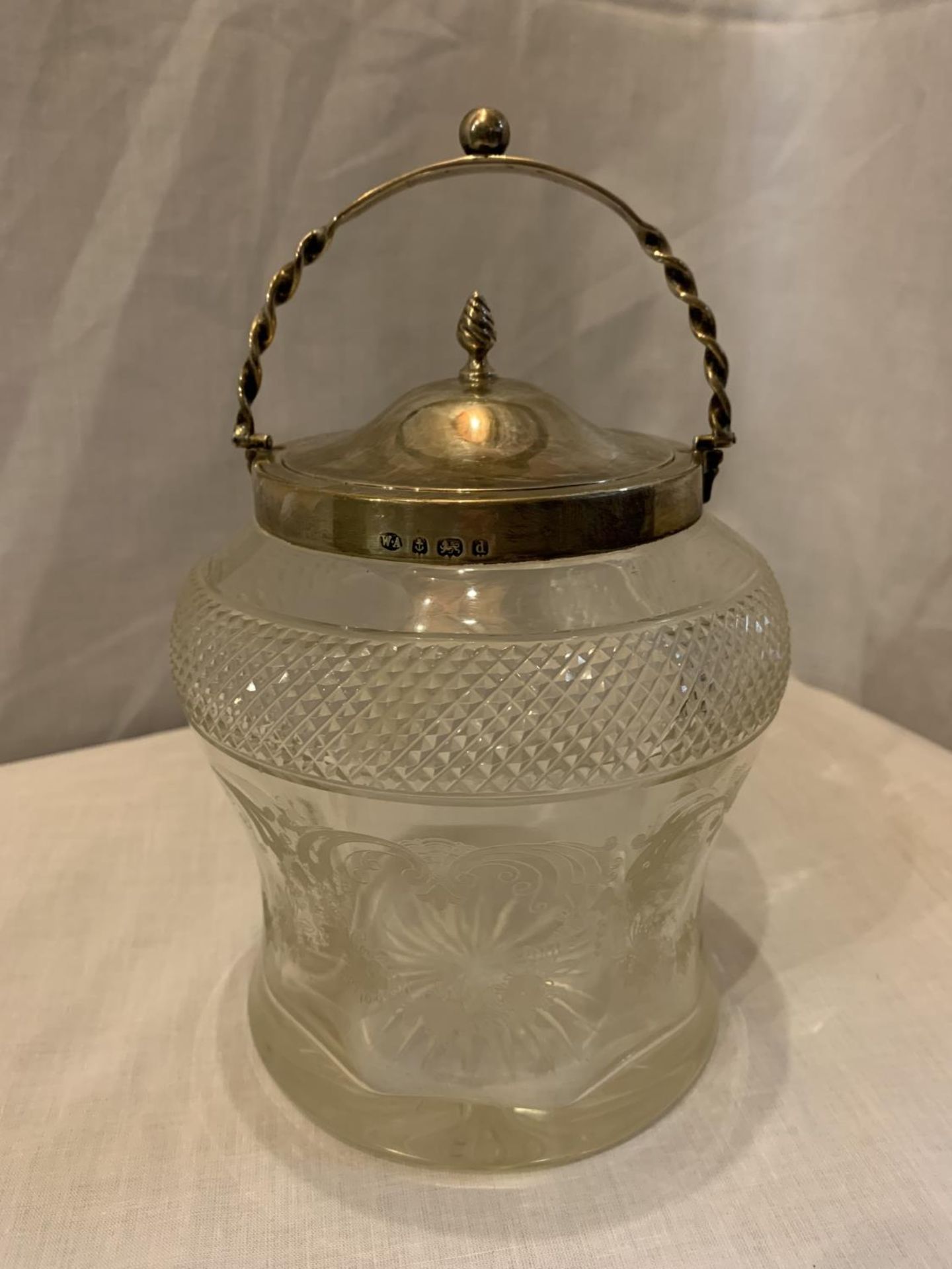 AN ETCHED AND CUT GLASS JAR WITH A HALLMARKED BIRMINGHAM SILVER RIM, LID AND HANDLE