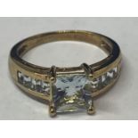 A 9 CARAT GOLD RING MARKED 375 WITH A LARGE CENTRAL PALE BLUE SQUARE STONE AND FOUR MATCHING