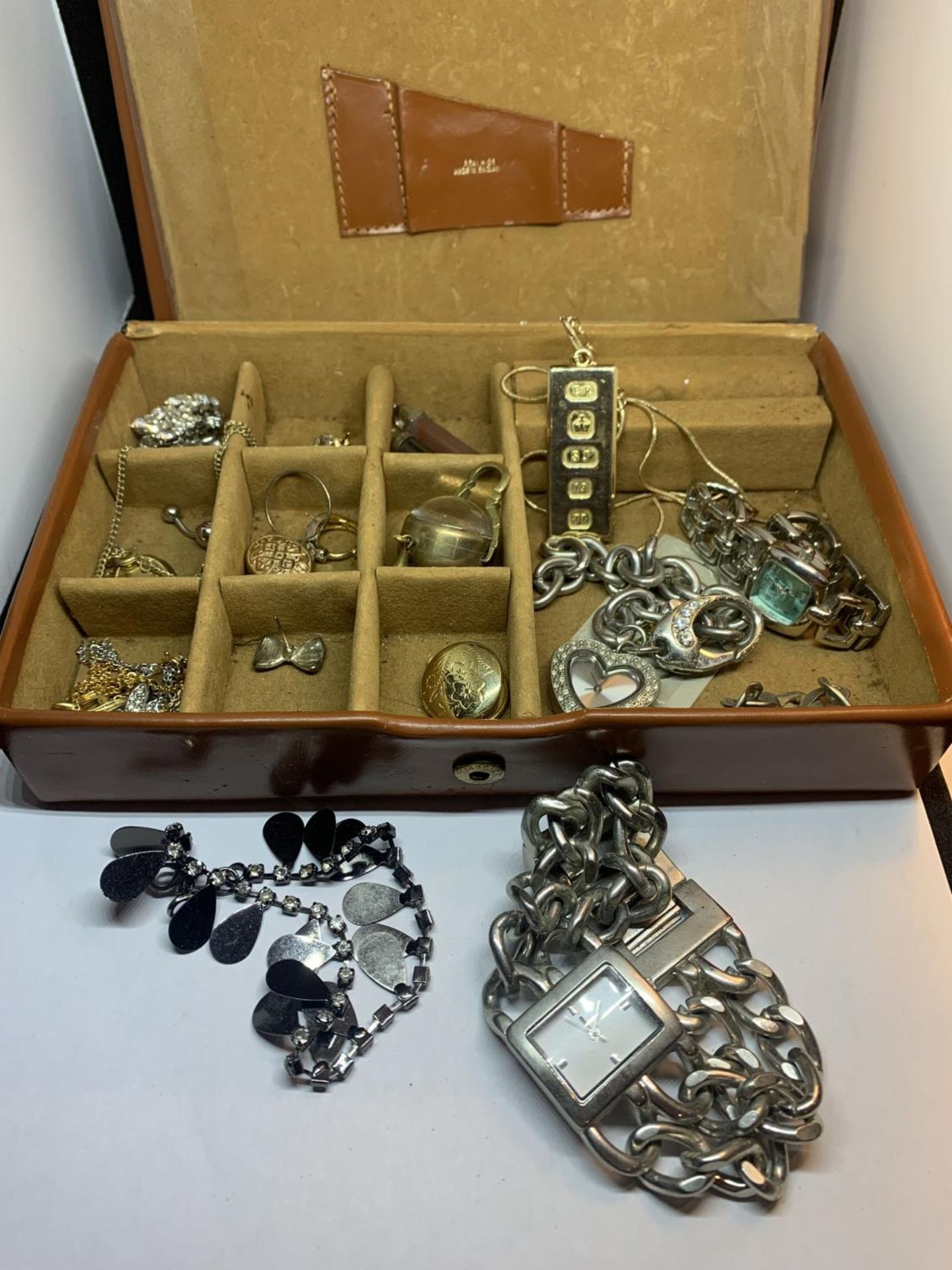 A BROWN LEATHER JEWELLERY BOX CONTAINING COSTUME JEWELLERY AND WATCHES