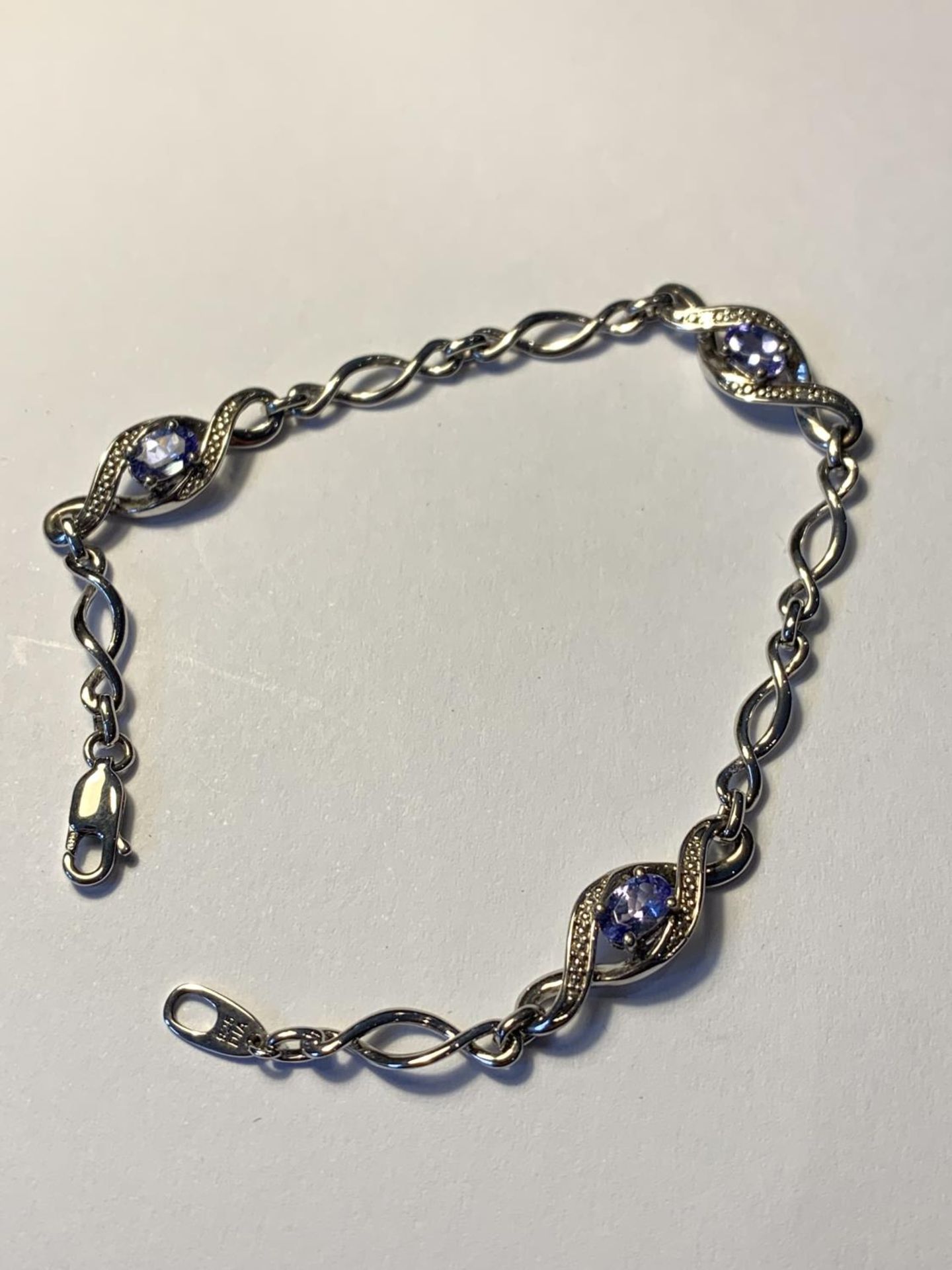 A SILVER BRACELET WITH POSSIBLY AQUAMARINES AND DIAMOND CHIPS IN A PRESENTATION BOX