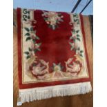 A FRINGED RED PATTERNED RUG
