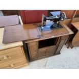 A SINGER SEWING MACHINE IN OAK CABINET COMPLETE WITH HEM STITCHER, OIL CAN, VARIOUS ACCESSORIES