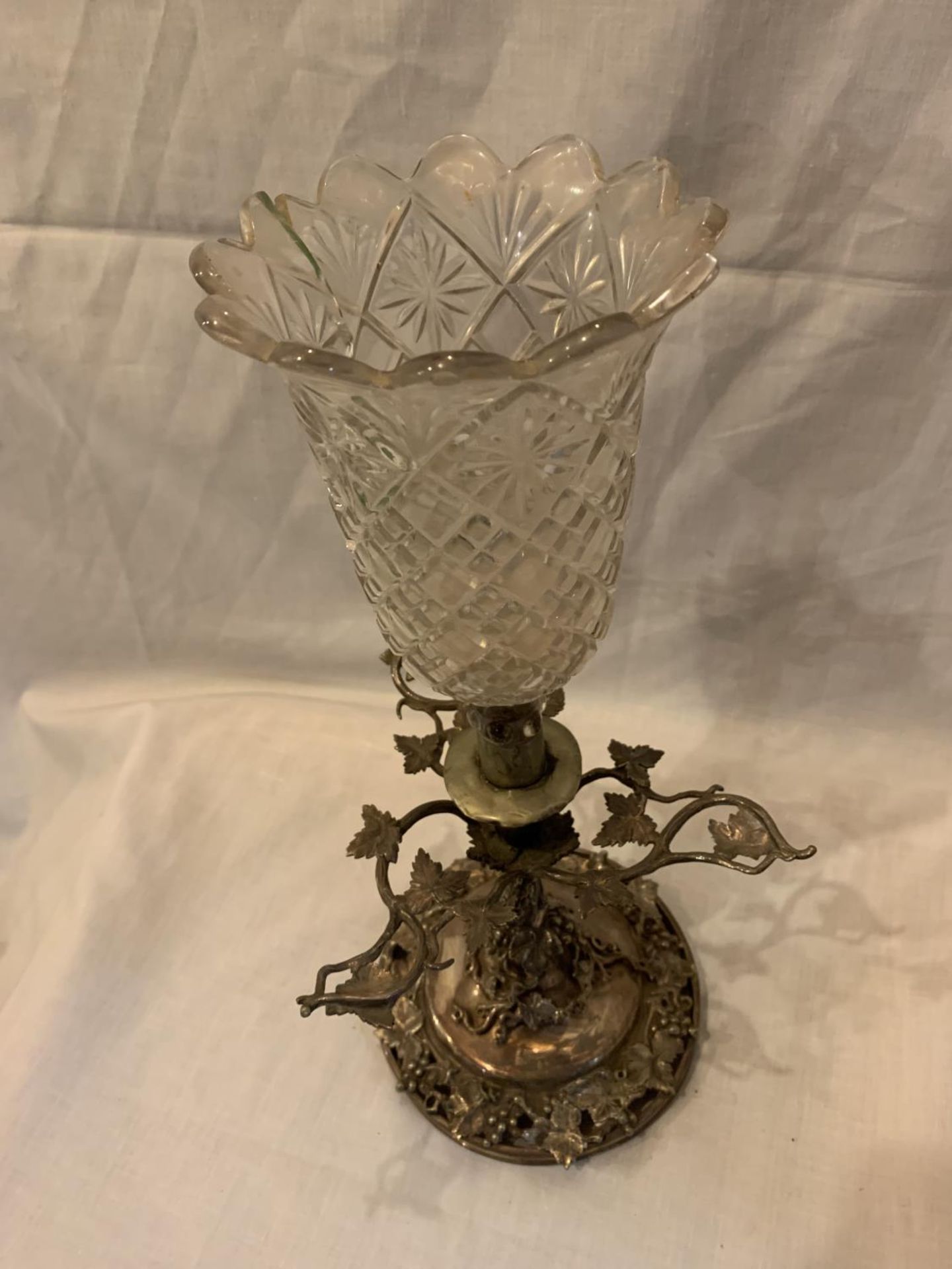 A SILVER PLATED CANDLE HOLDER WITH GLASS SHADE AND GRAPE VINE DECORATION 39CM TALL