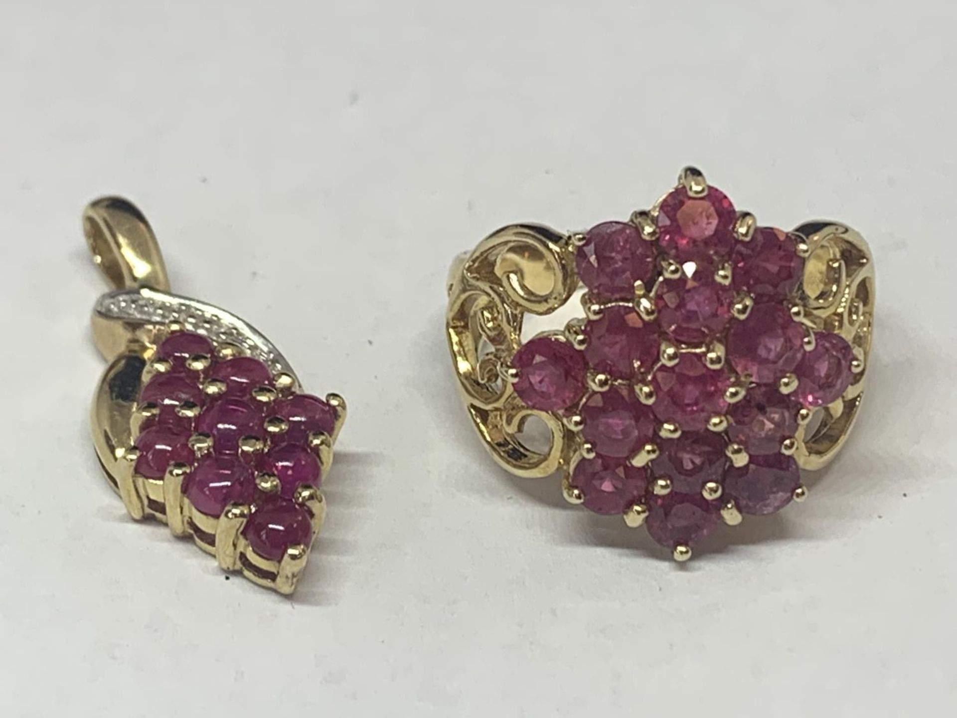 A 9 CARAT GOLD RING MARKED 375 WITH FIFTEEN PINK COLOURED STONES IN A CLUSTER DESIGN AND