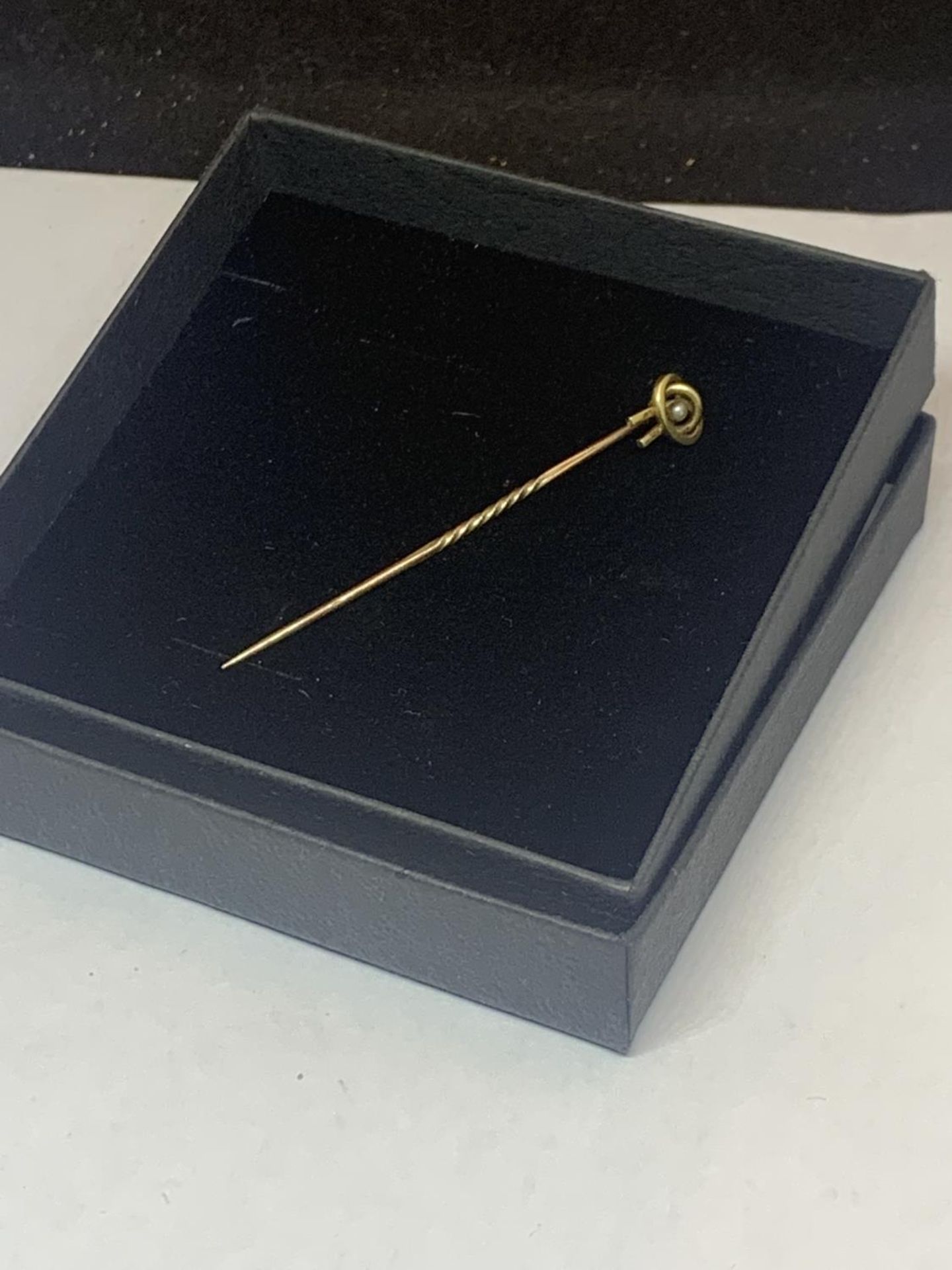 A VICTORIAN 15 CARAT GOLD STICK PIN WITH SEED PEARL IN A PRESENTATION BOX