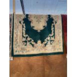 A GREEN AND CREAM PATTERNED RUG
