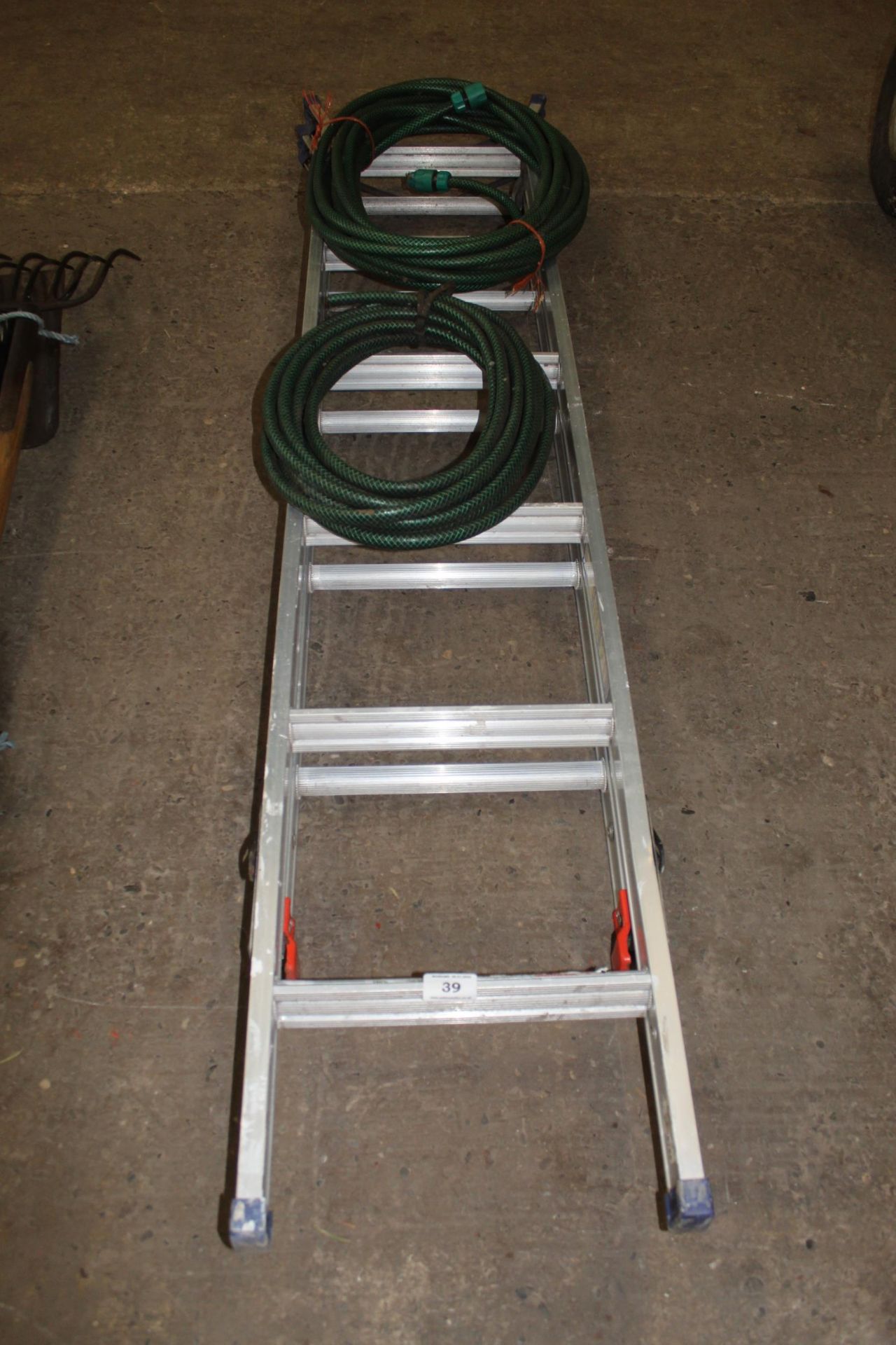 A THREE WAY STEP LADDER AND TWO HOSE PIPES NO VAT