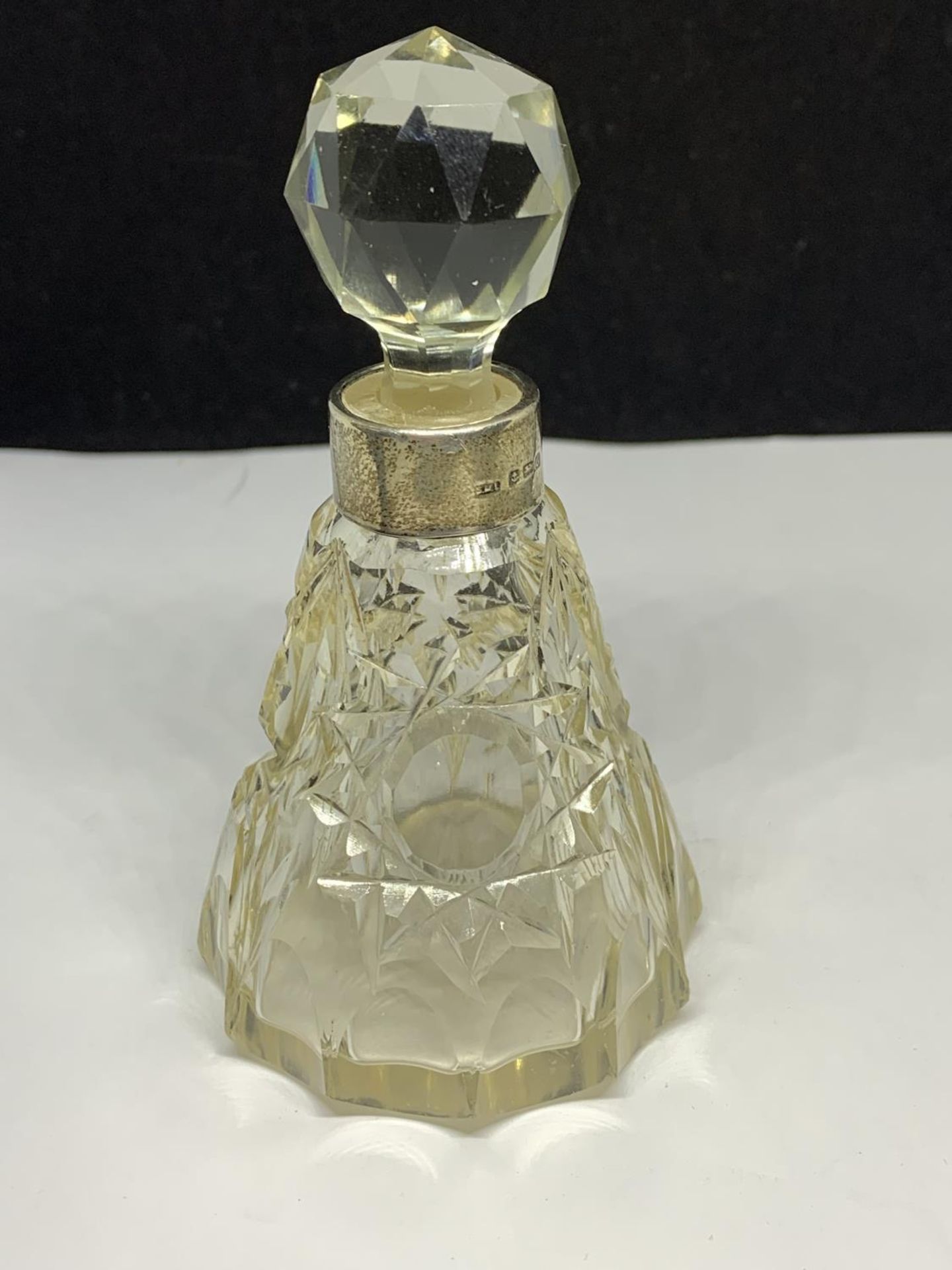 A CUT GLASS PERFUME BOTTLE WITH A HALLMARKED BIRMINGHAM 1931 SILVER COLLAR MAKER SML