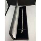 A 9 CARAT WHITE GOLD DIAMOND LINED BRACELET IN A KISS LINK DESIGN WITH A PRESENTATION BOX