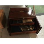 A MAHOGANY BOX WITH CAMPAIGN HANDLES, CUPBOARD DOORS OPENING TO THREE DRAWERS WITH CAMPAIGN