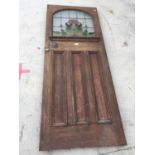 AN EARLY 20TH CENTURY COLOURED GLASS AND LEADED OAK DOOR, 31" WIDE