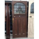 AN EARLY 20TH CENTURY COLOURED GLASS AND LEADED OAK DOOR WITH ARTS & CRAFTS STYLE COPPER PUSH