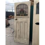 AN EARLY 20TH CENTURY COLOURED GLASS AND LEADED DOOR 31.5" WIDE