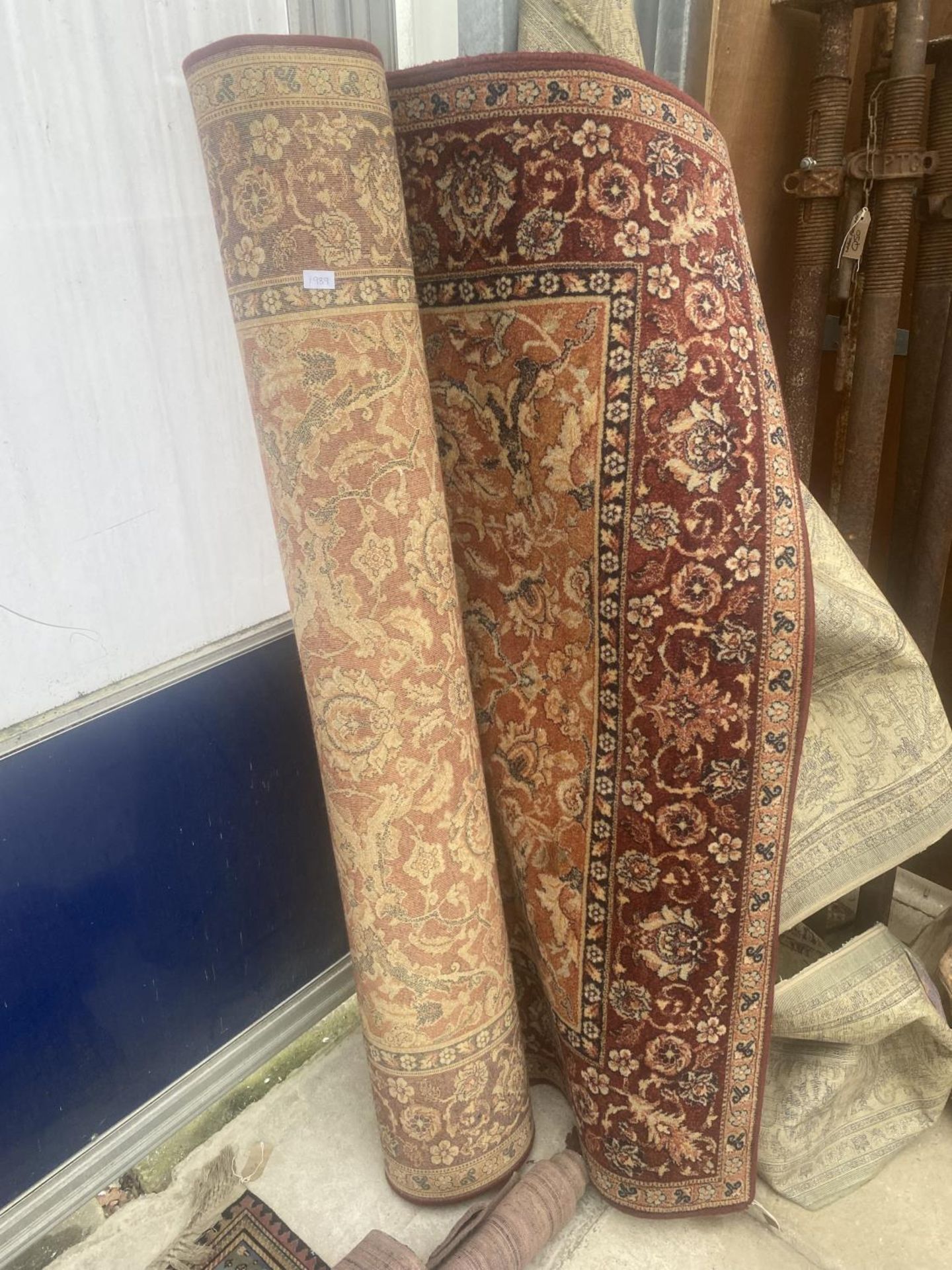 A LARGE RED AND CREAM PATTERNED RUG