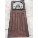 AN EARLY 20TH CENTURY COLOURED GLASS AND LEADED OAK DOOR WITH ARTS & CRAFTS STYLE COPPER PUSH