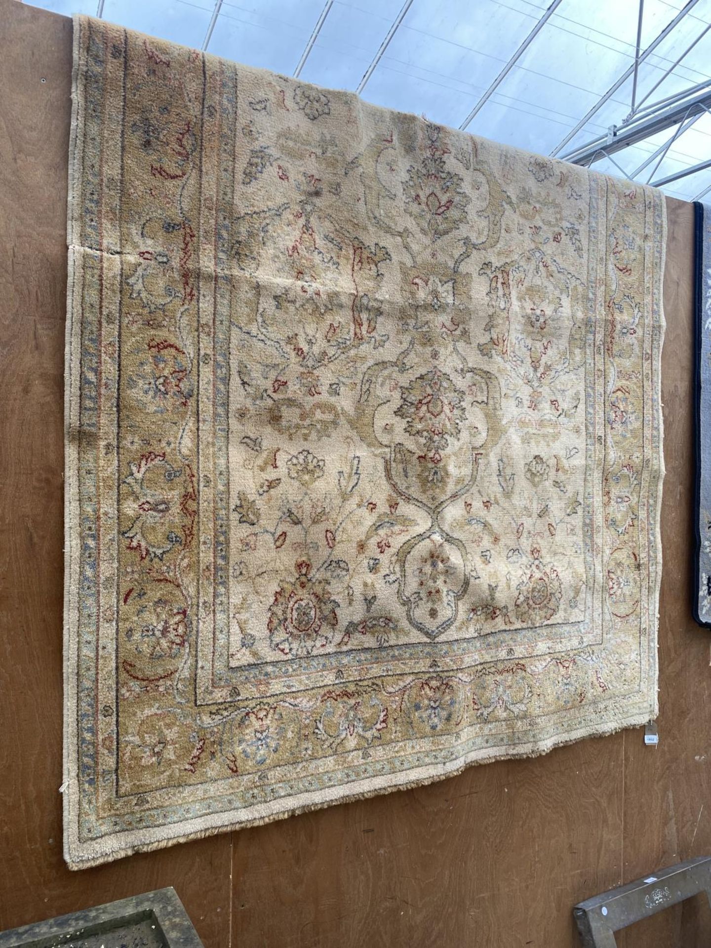 A LARGE CREAM PATTERNED RUG