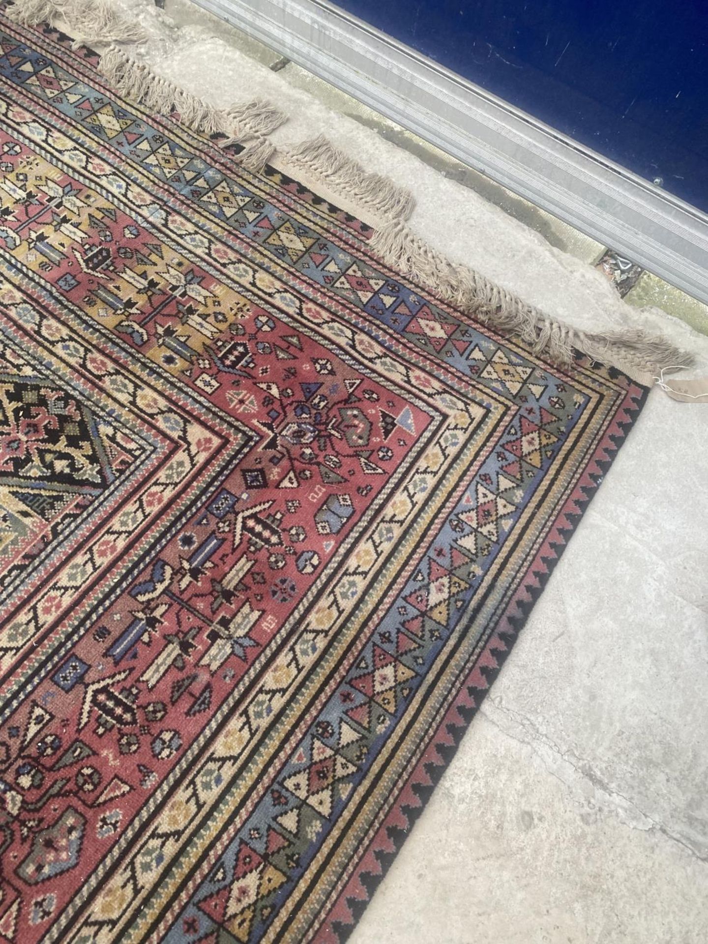 A LARGE RED PATTERNED RUG - Image 3 of 4