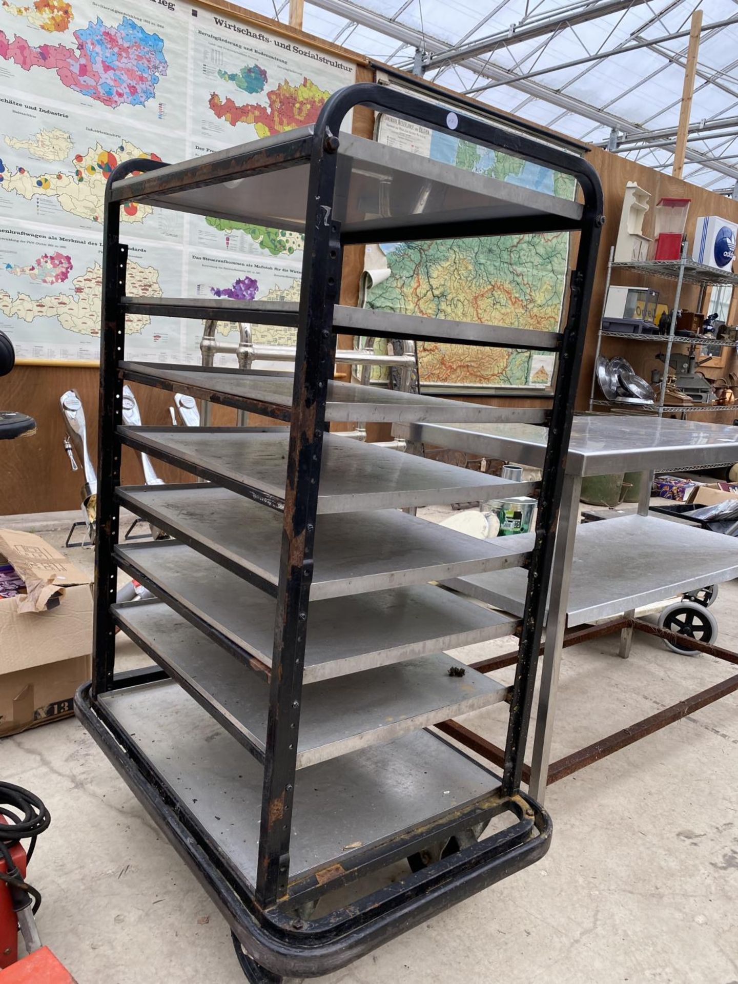 A FOUR WHEELED STAINLESS STEEL EIGHT TIERED TROLLEY