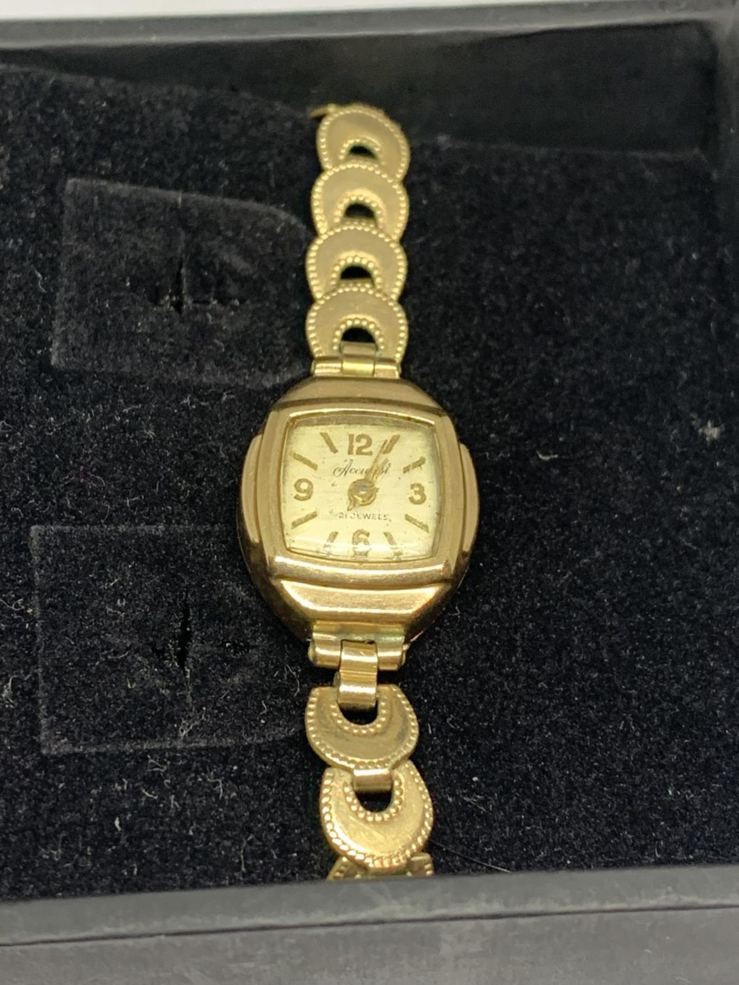 AN ACCURIST 21 JEWELS WRIST WATCH WITH A HALLMARKED 9 CARAT GOLD CASE ON A ROLLED GOLD STRAP NO