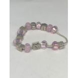 A SILVER PANDORA STYLE BRACELET WITH SIXTEEN VARIOUS PINK AND SILVER CHARMS TO INCLUDE A TEDDY,