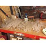 A LARGE AMOUNT OF GLASSWARE TO NCLUDE CUT GLASS EXAMPLES, DECANTERS, JUGS, WINE, SHERRY, BRANDY,