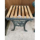 A WOODEN SLATTED GARDEN TABLE WITH CAST ENDS