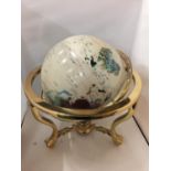 A LARGE GEMSTONE GLOBE ON A BRASS BASE