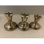 THREE HALLMARKED CANDLESTICKS TO INCLUDE A PAIR OF HALLMARKED BIRMINGHAM CANDLESTICKS AND A