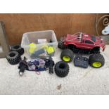 A LARGE REMOTE CONTROL CAR AND AN ASSORTMENT OF RC SPARE PARTS