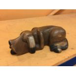 A WOODEN ORNAMENT OF A SLEEPING HOUND, LENGTH APPROX 34CM
