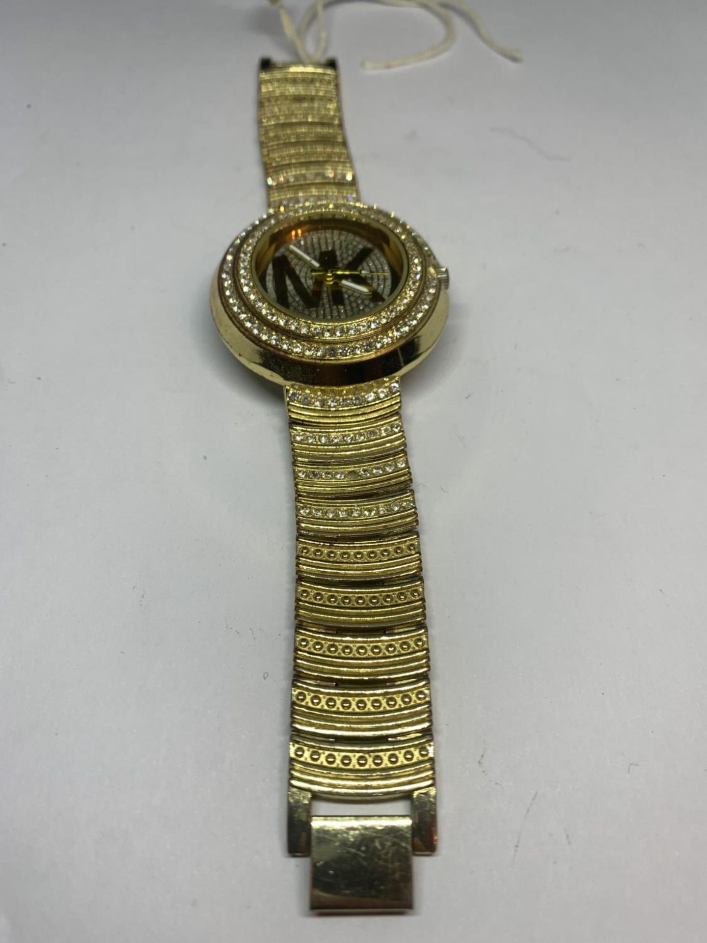 A DECORATIVE YELLOW METAL AND CLEAR STONE FASHION WRIST WATCH