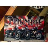 A METAL SIGN WITH A TRIUMPH MOTORBIKE