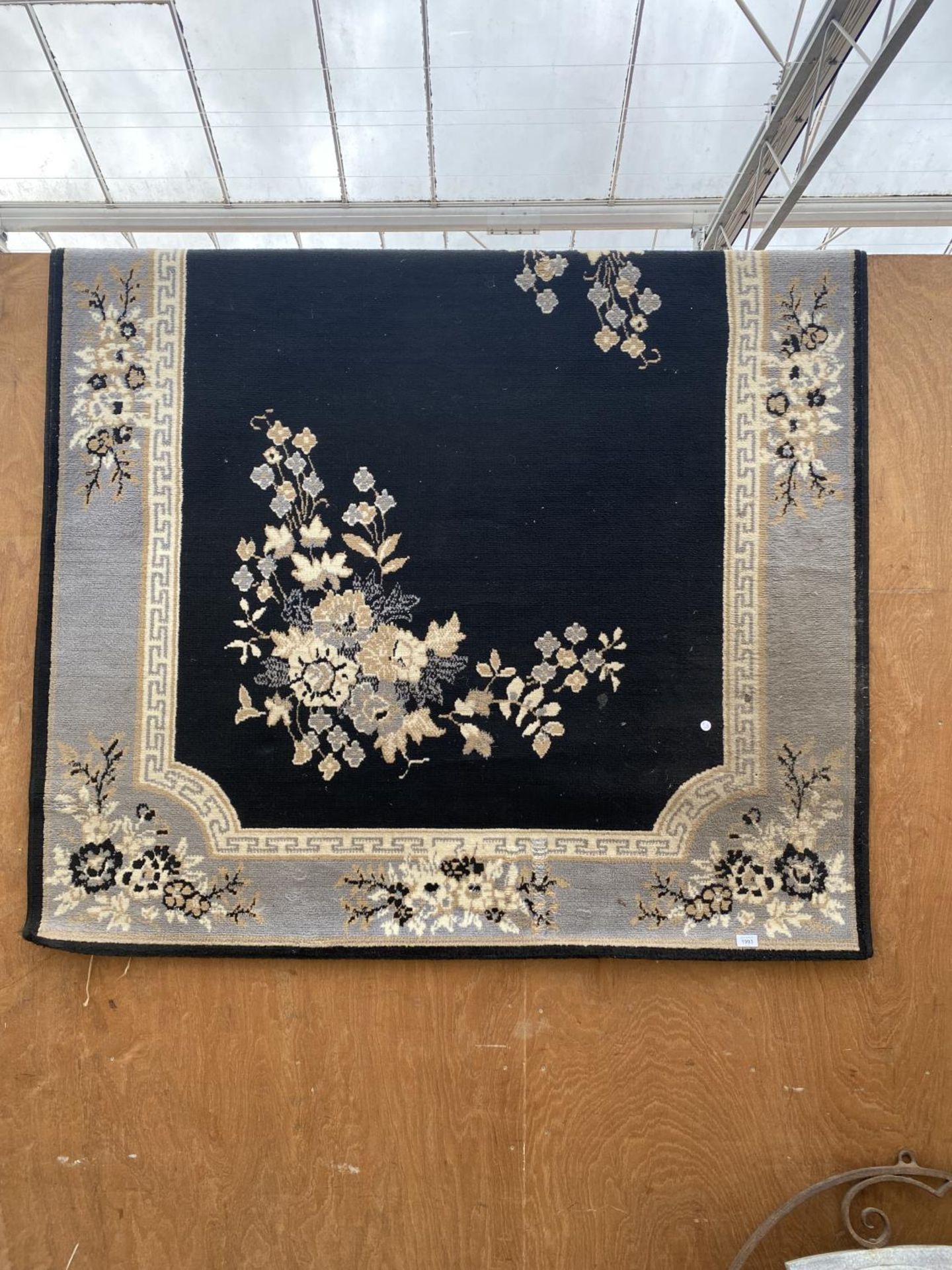 A LARGE BLACK PATTERNED RUG