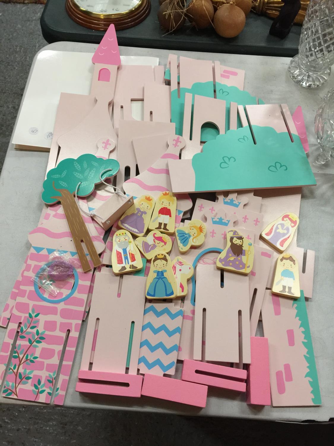 A CHILD'S WOODEN PRINCESS AND CASTLE SET WITH ASSEMBLY INSTRUCTIONS